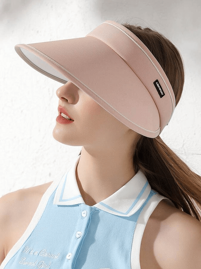 Woman wearing a pink foldable visor cap, perfect for sun protection, with an adjustable fit and stylish design.